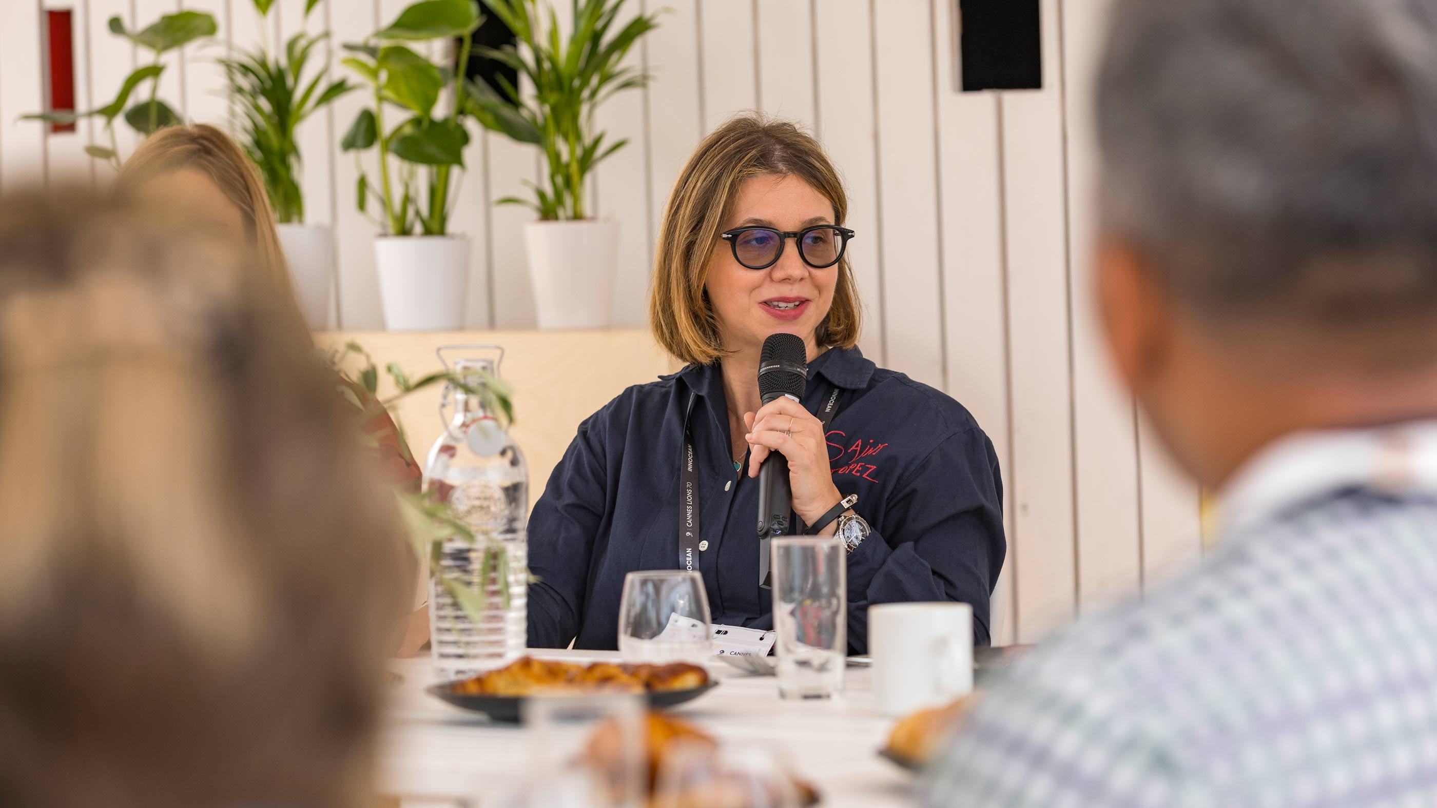 Marie Gulin-Merle, global VP of ads marketing at Google, wears sunglasses and a casual black jacket while speaking at a round-table discussion about AI in marketing at the Google Beach during the Cannes Lions International Festival of Creativity.